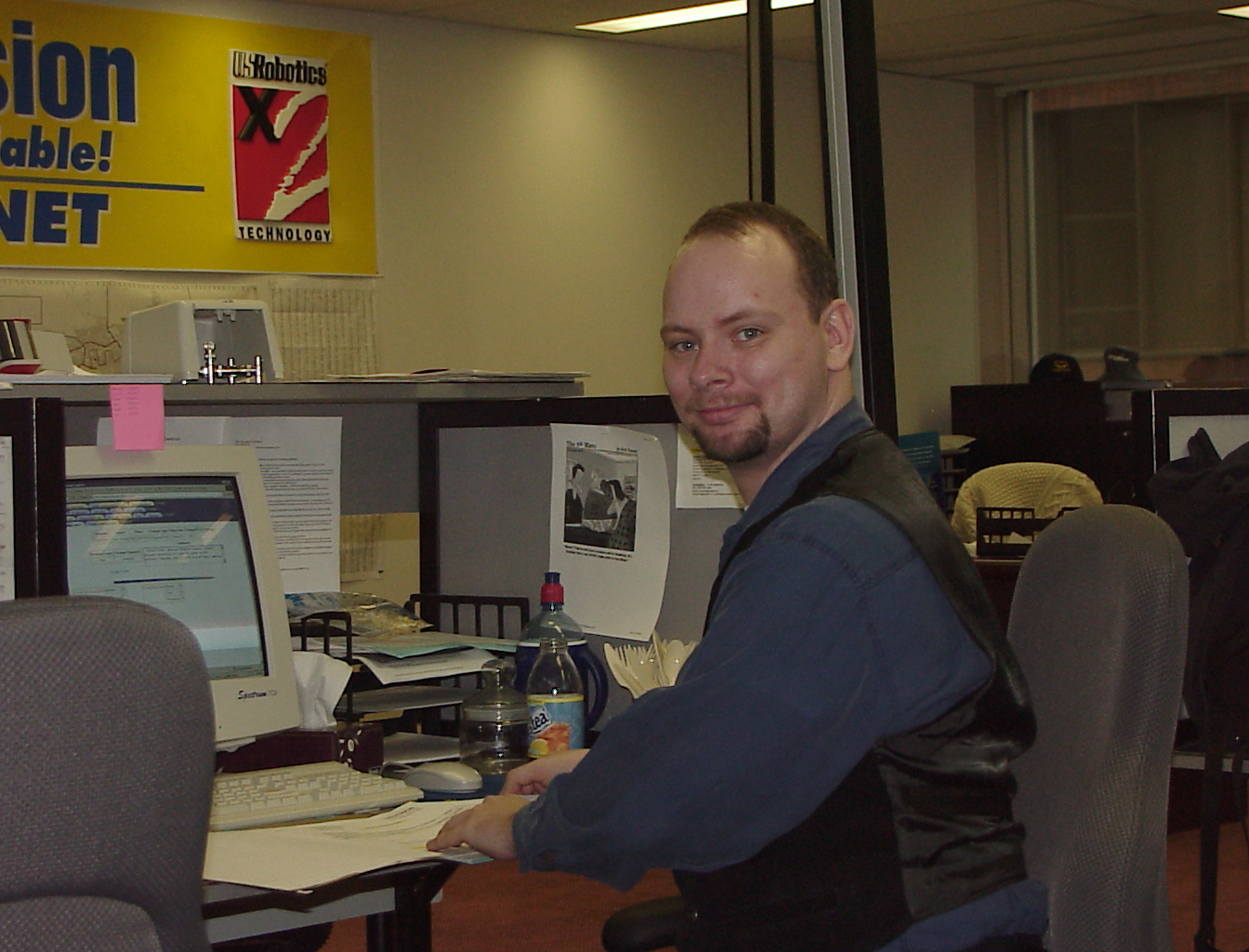 At the desk, under the US Robotics banner